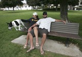 Sarah Hafley and Craig Cooksey sit on a bench while taking their dog Brady for a romp at the Cemetery Memorial Park on Wednesday in Ventura. Some people want dogs banned from the historic cemetery. 
